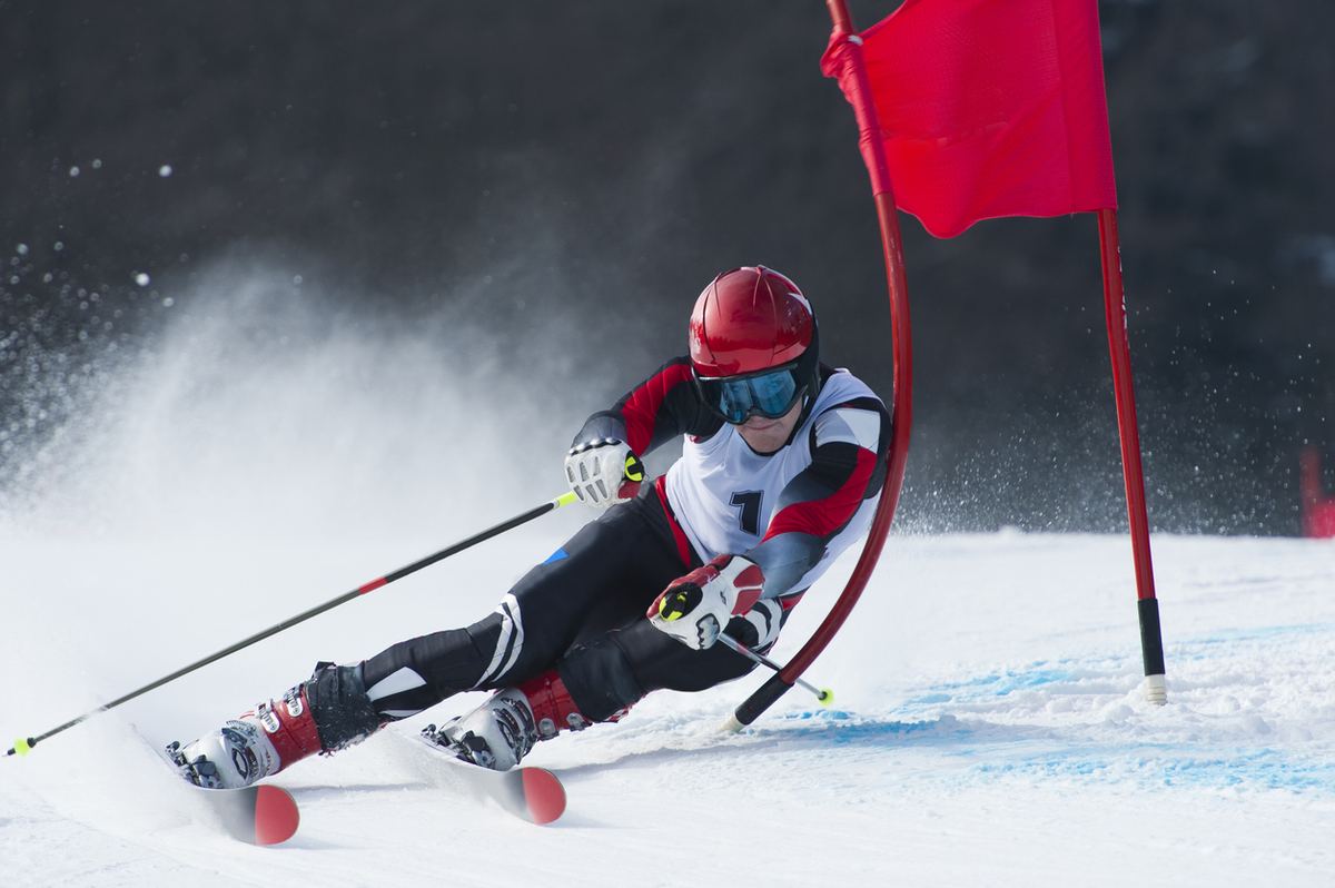 Skirennläufer beim Riesenslalom an einem roten Tor